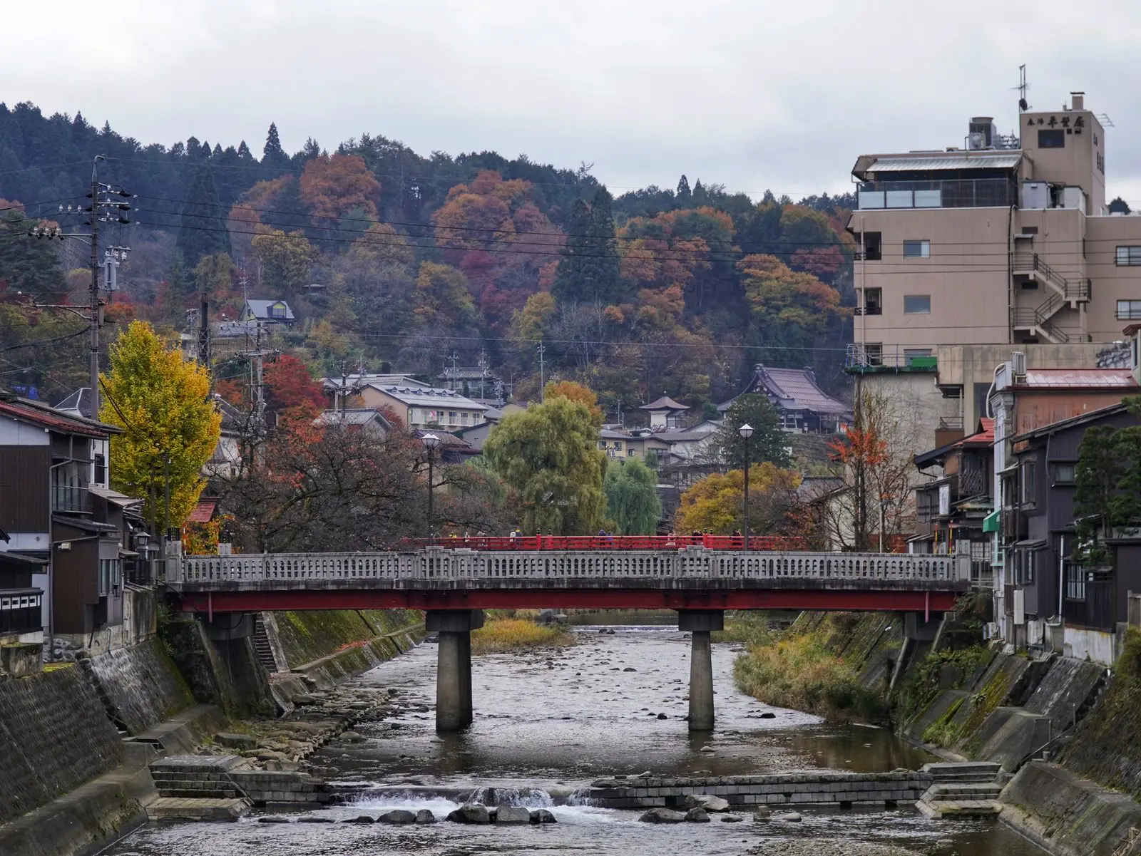 Bridge over the Miyagawa river in Takayama with autumn colour on the hills behind