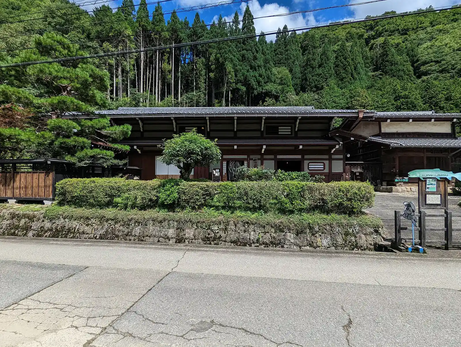 Long timber Taue heritage house behind a hedge in rural Takayama