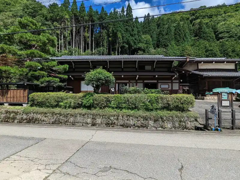 Long timber Taue heritage house behind a hedge in rural Takayama