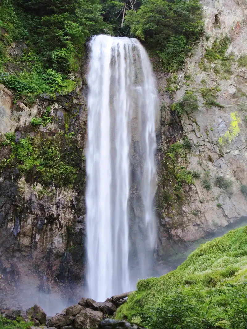 Hirayu Falls in summer, a wide white drop between green, moss-covered cliffs