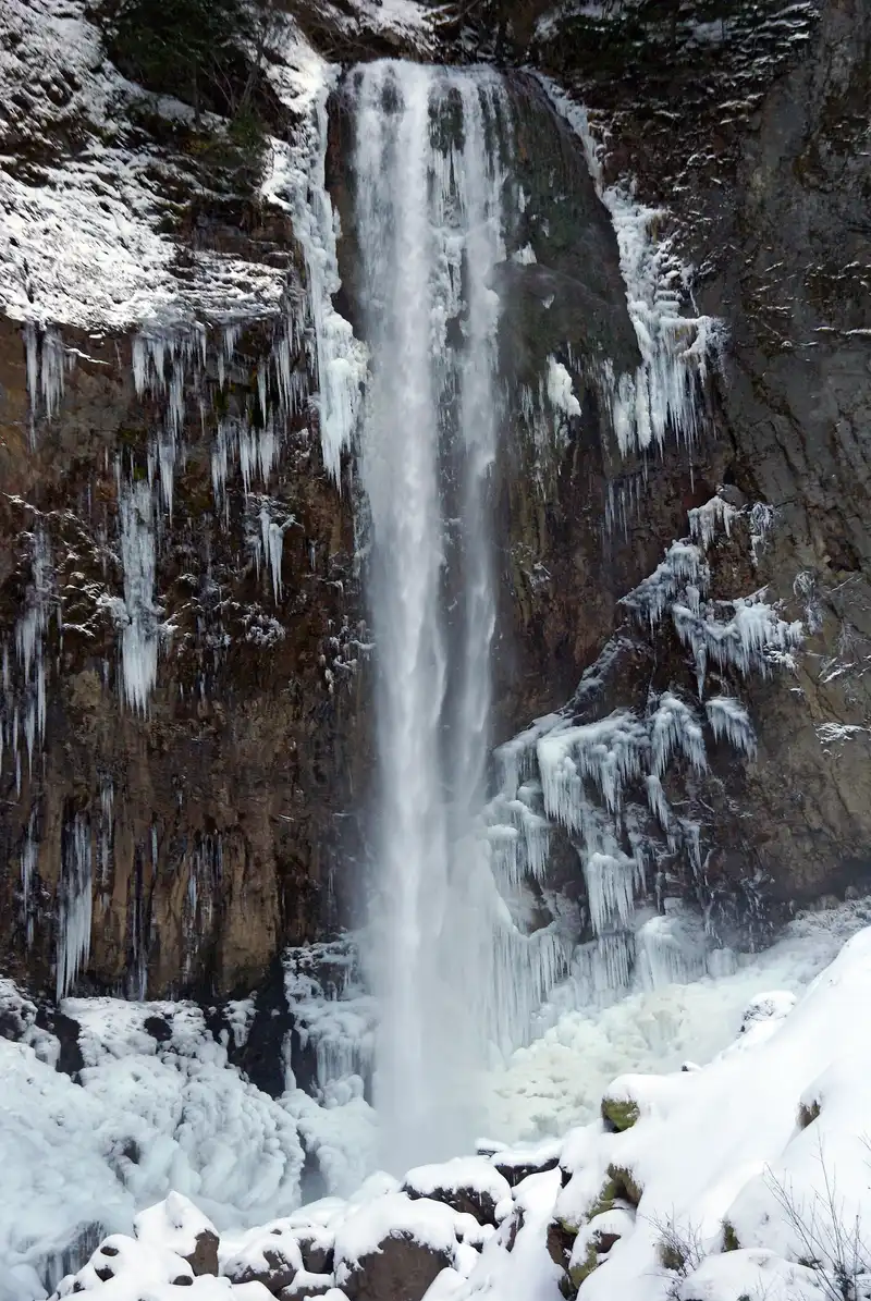 Close view of Hirayu Falls in winter with ice hanging from the cliff on both sides