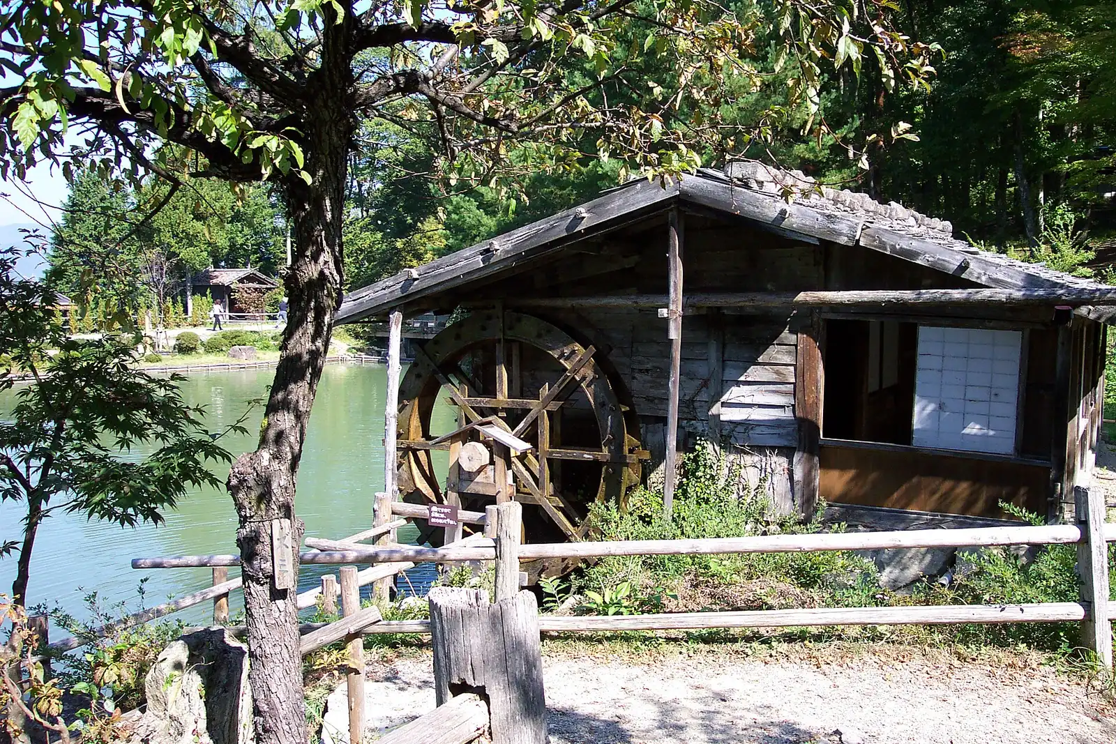 Wooden water mill beside the pond at Hida Folk Village