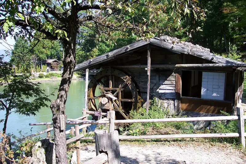 Wooden water mill beside the pond at Hida Folk Village