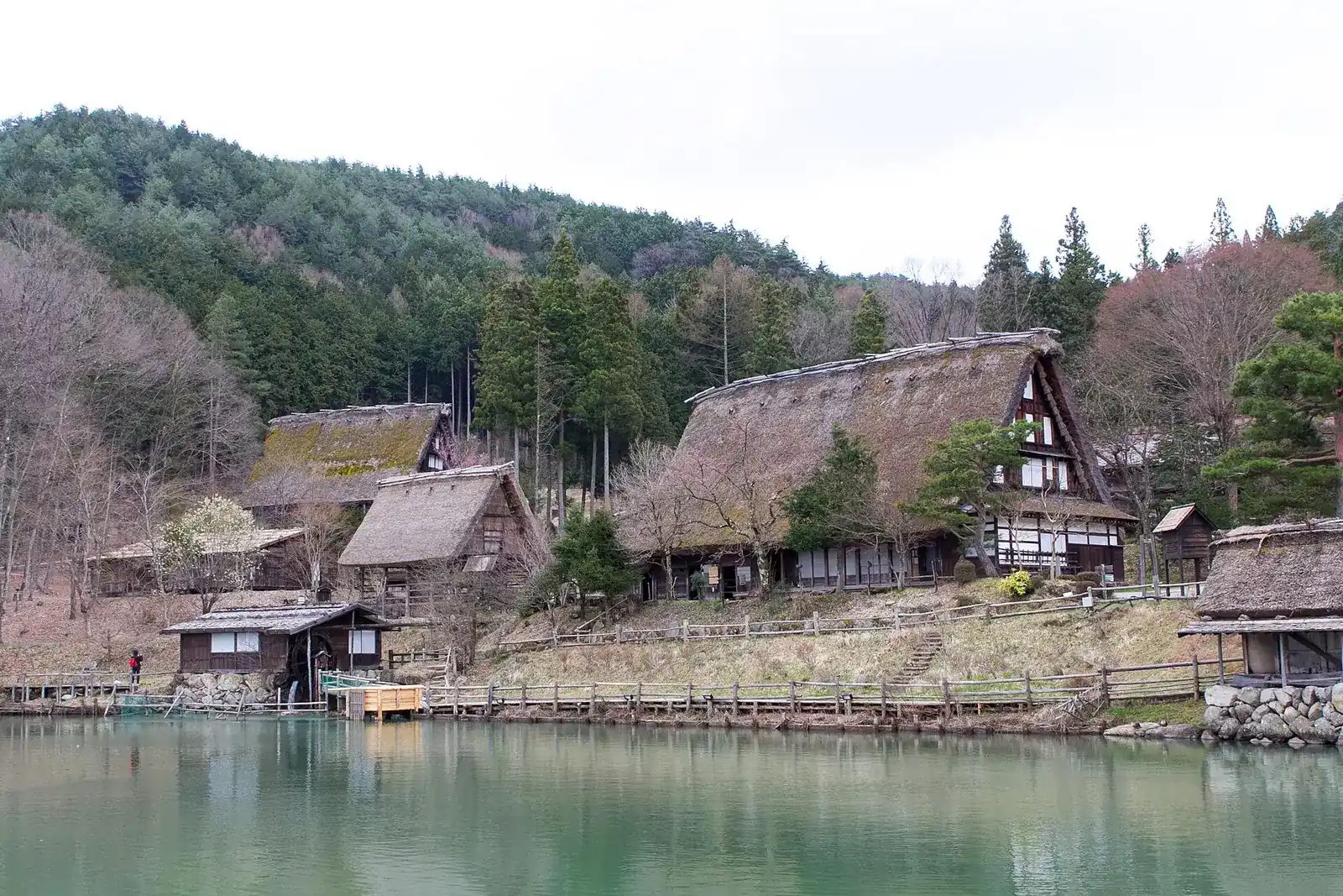 Thatched farmhouses around the pond at Hida Folk Village before the spring leaves