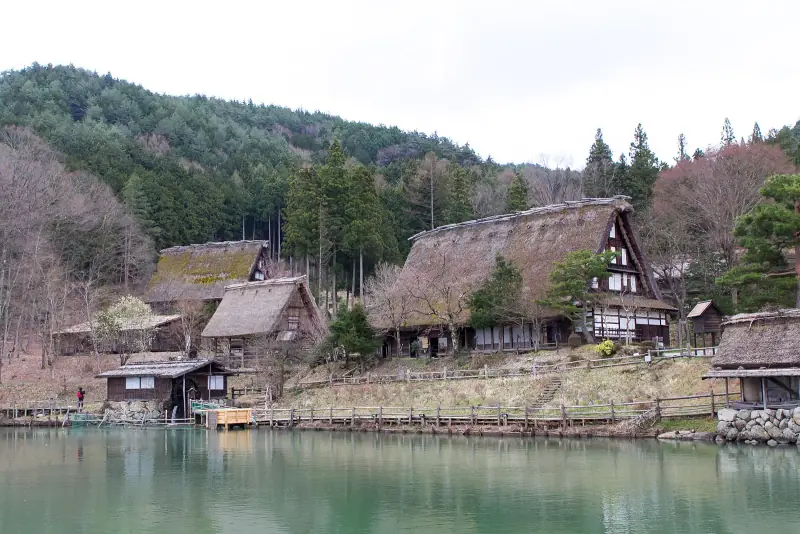 Thatched farmhouses around the pond at Hida Folk Village before the spring leaves