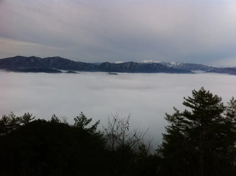 Sea of cloud filling the Hida valley seen from Mount Anpo, snow-capped peaks on the horizon