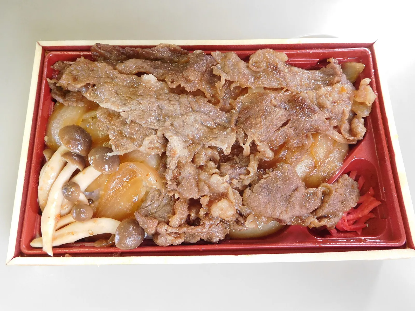 Hida beef box lunch: sliced beef over simmered vegetables and mushrooms