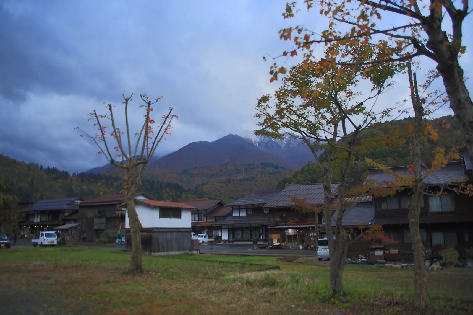 Shirakawa-go village houses below autumn hills and cloud-capped peaks