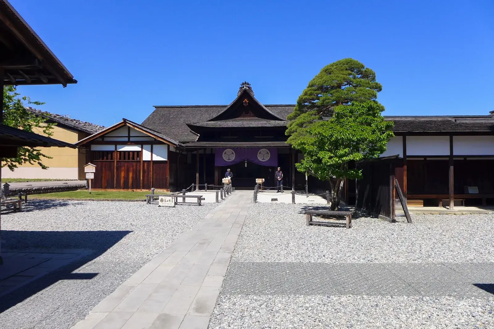 Courtyard and main gate of Takayama Jinya under a clear blue sky