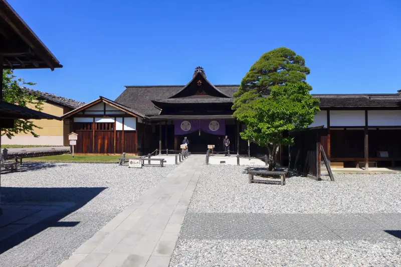 Courtyard and main gate of Takayama Jinya under a clear blue sky